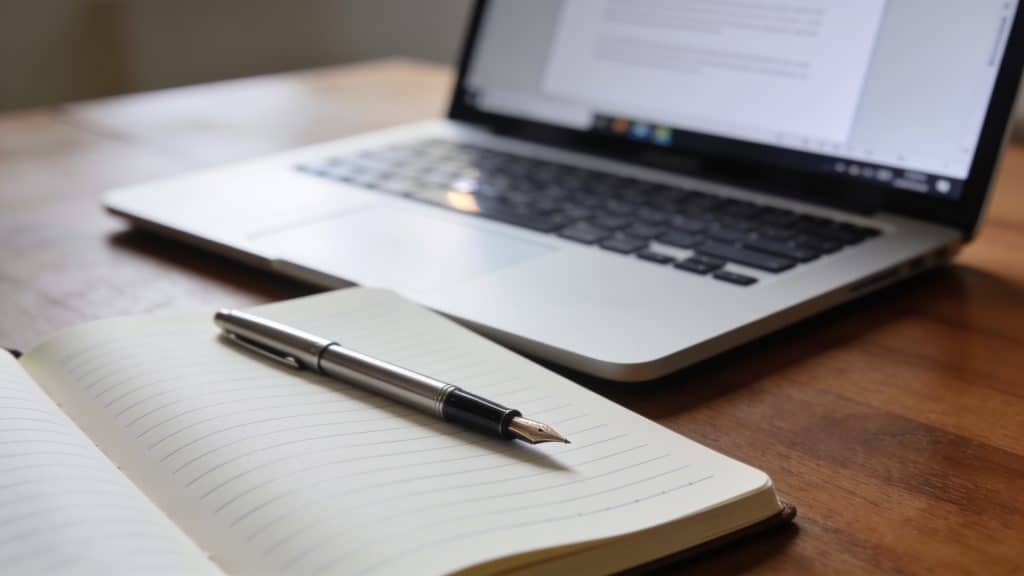 Bureau range avec cahier ouvert stylo et ordinateur