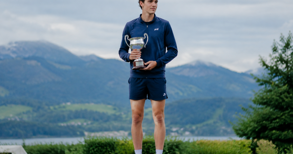 Jeune homme debout sur un podium tenant une coupe